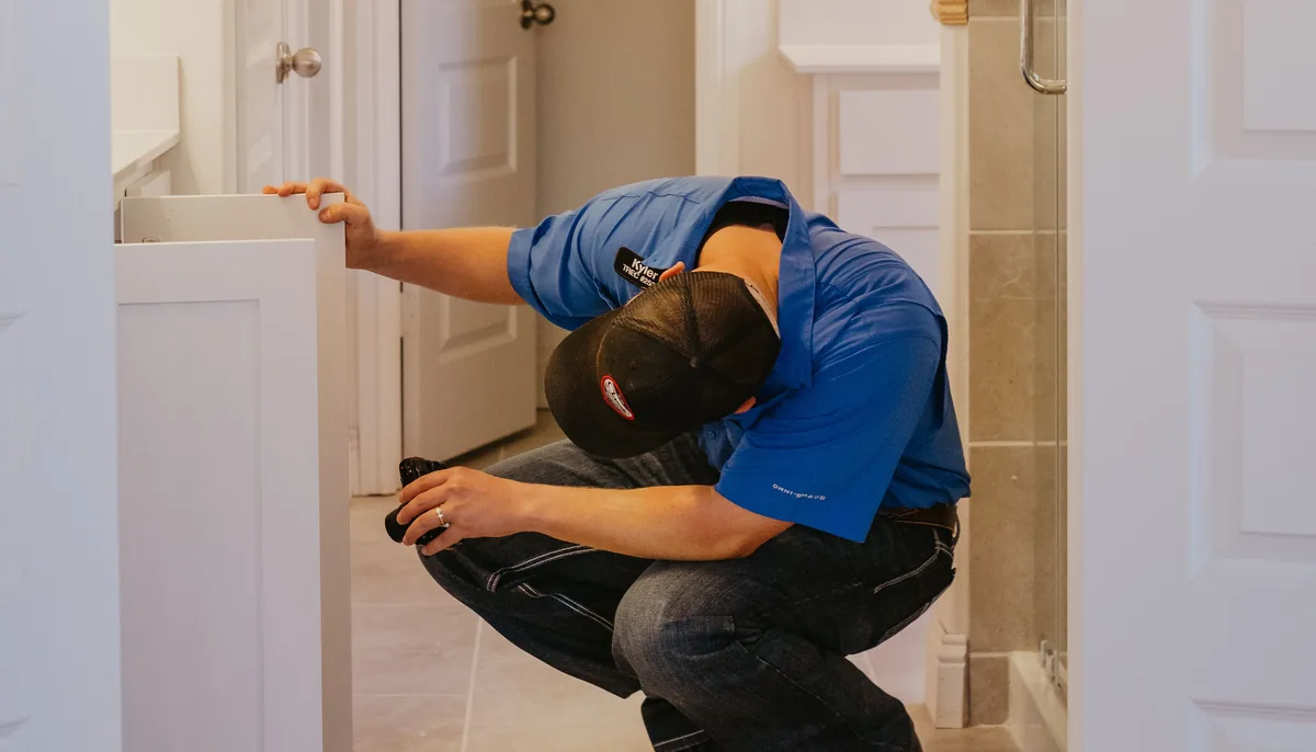 Kissee Inspections inspector checking under a bathroom vanity